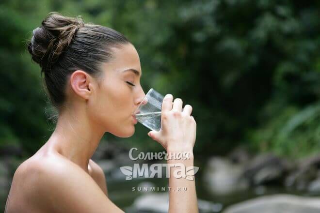 Девушка пьет воду на природе, фото