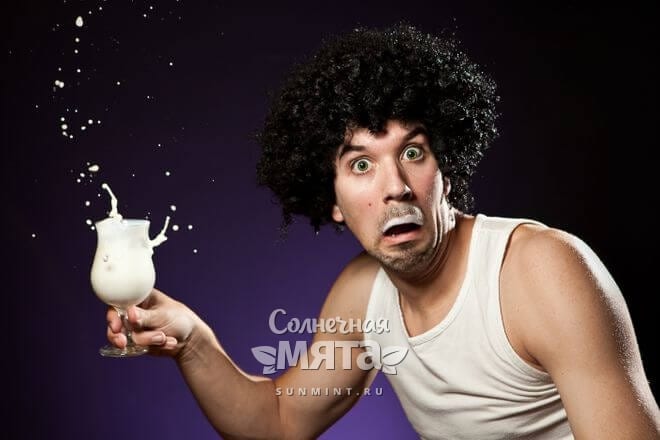 Шокированный мужчина держит в руке стакан молока, фото