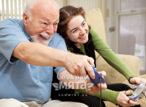 Дед с внучкой играют в видеоигры, фото