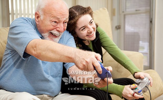Дед с внучкой играют в видеоигры, фото