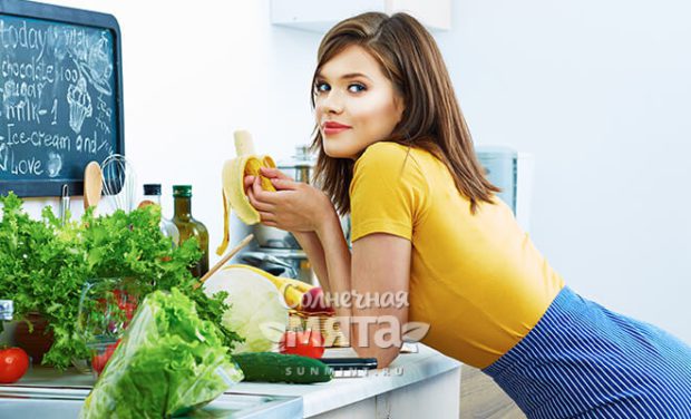 Девушка на кухне ест банан, фото