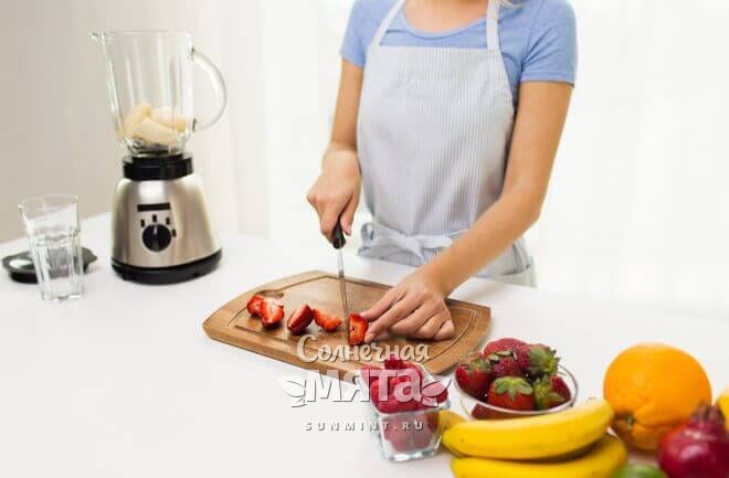 Девушка на кухне разрезает ягоды и фрукты, фото